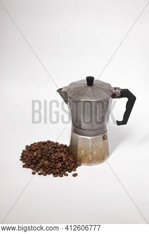 Geyser Coffee Maker Or Moka Pot Isolated On White Background With Coffee Beans Nearby.