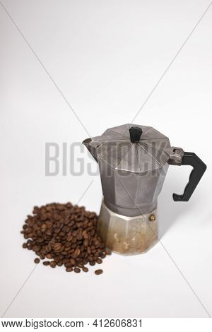 Geyser Coffee Maker Or Moka Pot Isolated On White Background With Coffee Beans Nearby.