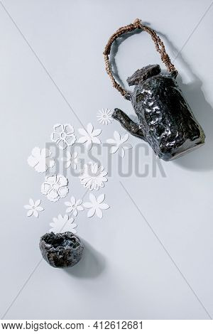 Creative Layout With White Paper Flowers Over Gray