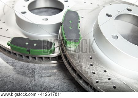 Brake Pads And Perforated Brake Discs On A Stone Gray Table