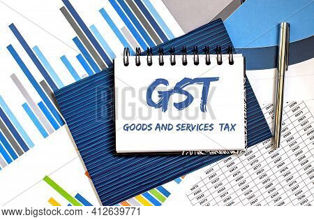 Business Concept. Notebook With Text Gst On The Chart Background