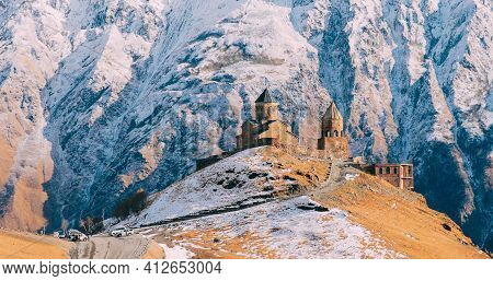 Stepantsminda, Gergeti, Georgia. Famous Gergeti Trinity Tsminda Sameba Church In Late Autumn Landsca