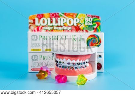 Moscow, Russia - 9th Matra 2021: Childrens Toothpastes And Artificial Jaw With Colored Braces On A B