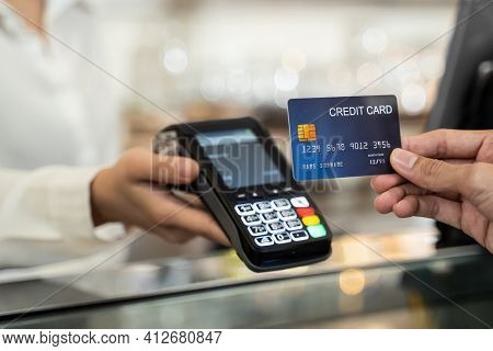 Close Up Shot Of Customer Hand Using Dummy Credit Card For Payment To Waitress At Cashier In Cafe Re