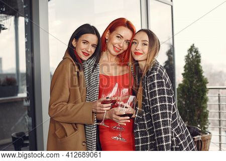 Happy Women Friends Drinking Red Wine Laughing In Teracce