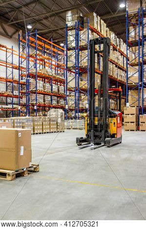 Interior Of A Modern Warehouse Storage Of Retail Shop With Forklift Near Shelves