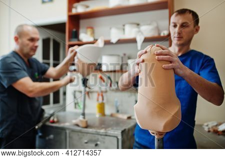 Two Prosthetist Man Workers Making Prosthetic Leg While Working In Laboratory.