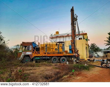 Closeup Of Borewell Drilling Lorry Or Vehicles With Tools, Pipe, Machine And Working Labour And Puja