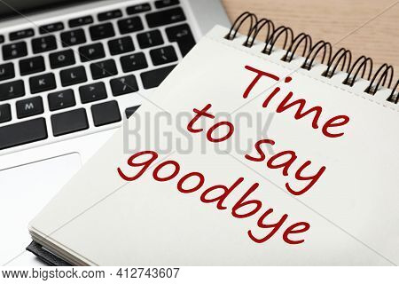 Notebook With Phrase Time To Say Goodbye And Laptop On Table, Closeup