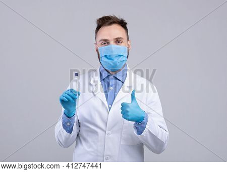 Portrait Of Doctor In Mask And Gloves Holding Covid-19 Pcr Test Tube And Showing Thumb Up Gesture On