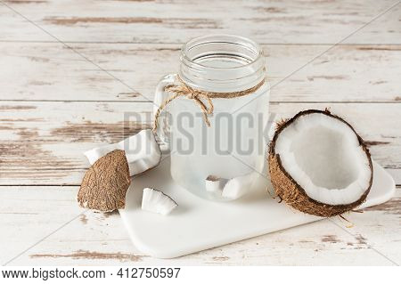 Coconut Water In A Glass Masson Jar On White Wooden Table. Fresh Detox Coconut Juice.