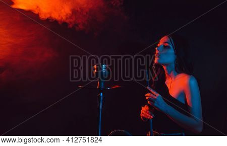 A Young Girl Enjoys Smoking A Hookah, Sheesha. Photo With Space For Text
