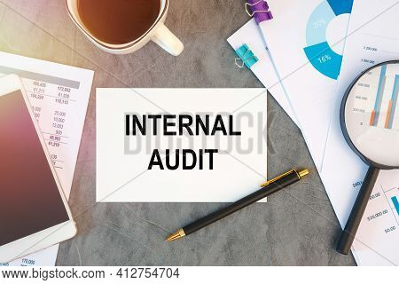 Internal Audit Is Written In A Document On The Office Desk With Office Accessories, Coffee, Diagram 