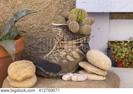 A Funny Still Life, In A Corner Of The Small Town Of Ambel, Formed By An Old Mountain Boot, Turned I