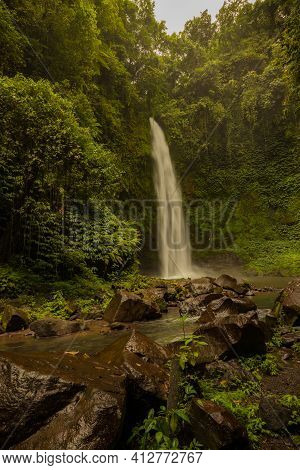 Waterfall Landscape. Beautiful Hidden Waterfall In Tropical Rainforest. Foreground With Big Stones. 