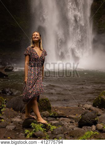 Young Caucasian Woman Walking In Tropical Forest Near The Waterfall. Nature And Environment Concept.