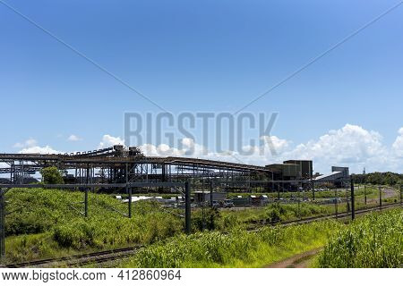 Mackay, Queensland, Australia - March 2021: Electric Railway Line In Front Of Overhead Conveyors To 