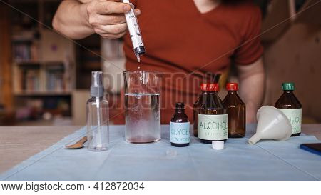 A Middle Aged Man Reading Receipt From Mobile Phone And Doing Hand Sanitizer At Home