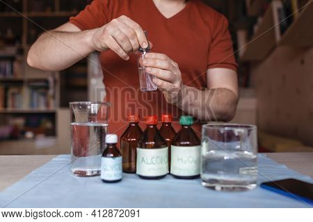 A Middle Aged Man Reading Receipt From Mobile Phone And Doing Hand Sanitizer At Home