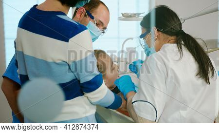 Dentists With Gloves And Mask Removes Tooth Decay Drilling Teeth During Surgery. Dentistry Doctors T