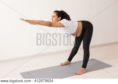 Young Flexible Pregnant Woman Doing Gymnastics On Rug On The Floor On White Background. The Concept 