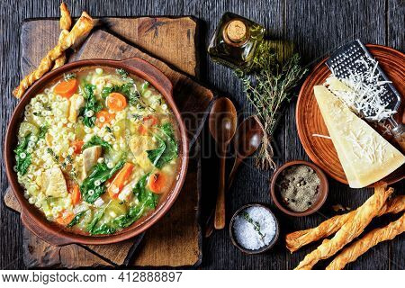 Chicken Kale Soup With Pasta Anellini And Vegetables In A Clay Bowl On A Dark Wooden Board With Gris