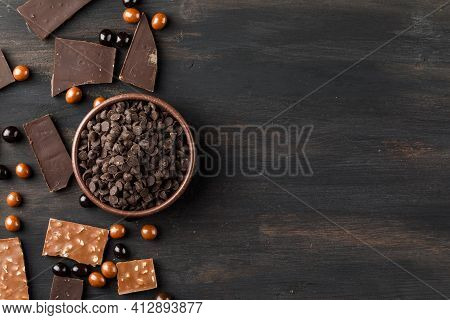 Choco Drops With Chocoballs, Choco Bars In A Clay Bowl On Wooden Background, Flat Lay.