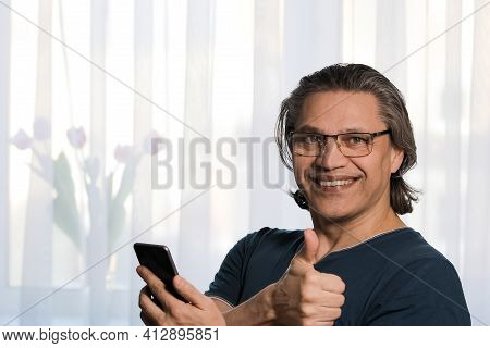 An Adult Man Puts On Glasses For Sight. Joy On The Face.