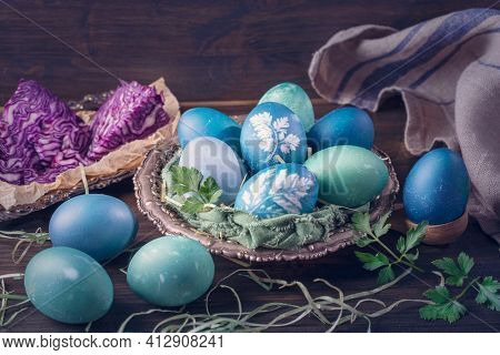 Natural dyed easter eggs on a wooden background. Colored with red cabbage. For greenish blue red cabbage with soda can be used.