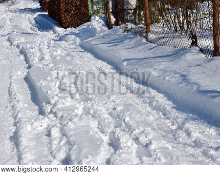 Winding Footprints Of Hikers In The Deep Snow Between The Trees