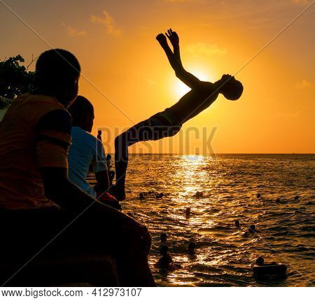 Stone Town, Zanzibar, Tanzania - January 2020: Locals Run And Jump Into The Sea From Stone Embarkmen