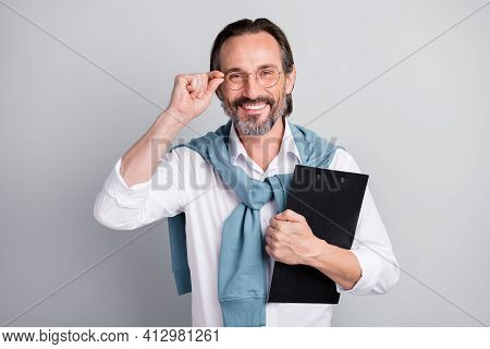 Portrait Of Handsome Satisfied Man Arm Touch Eyewear Hold Clipboard Isolated On Grey Color Backgroun