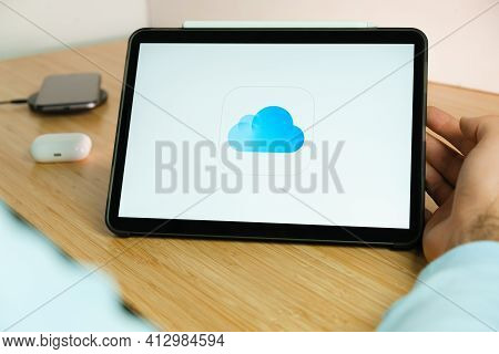 Icloud Logo On The Screen Of Ipad Tablet With Smart Phone Iphone Charging On The Wireless Charger An