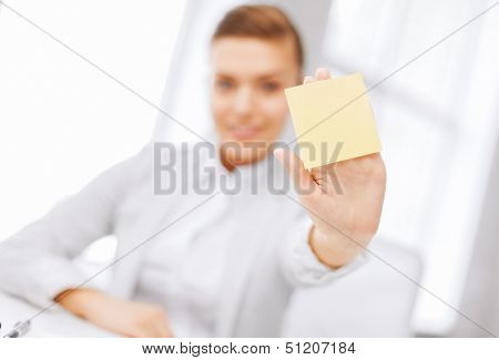 business, office, school and education concept - smiling businesswoman showing blank sticky note