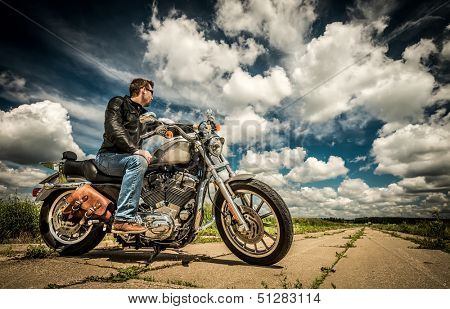 Biker in sunglasses and leather jacket on the road