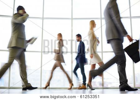 White collar workers going down office corridor at the end of working day