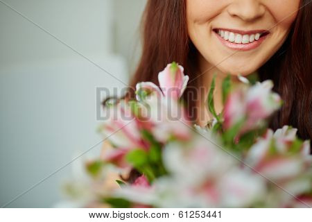 Close-up of female toothy smile and flowers