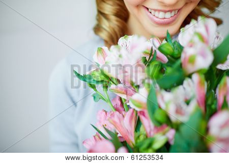 Close-up of smiling female smelling pink flowers