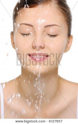 Mujer con una gotas de agua en el rostro puro