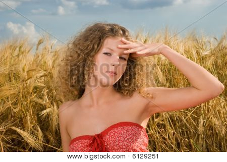 Hermosa chica en el picnic en el campo de trigo