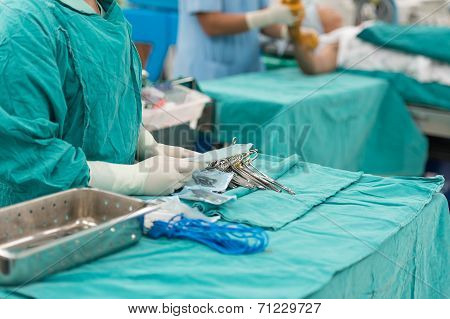 Scrub Nurse Preparing Tools For Operation
