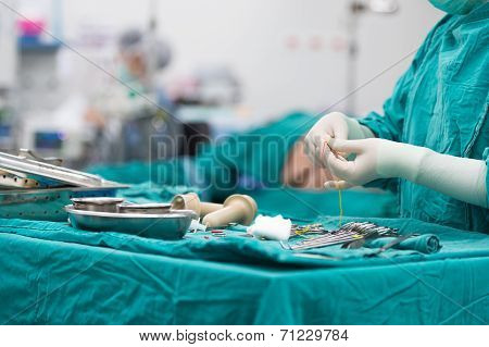 Scrub Nurse Preparing Tools For Operation