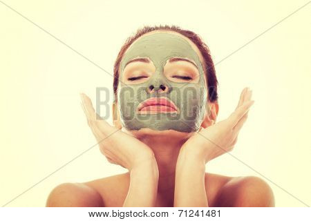 Beautifu toplessl woman with facial mask having her eyes closed. Isolated on white.