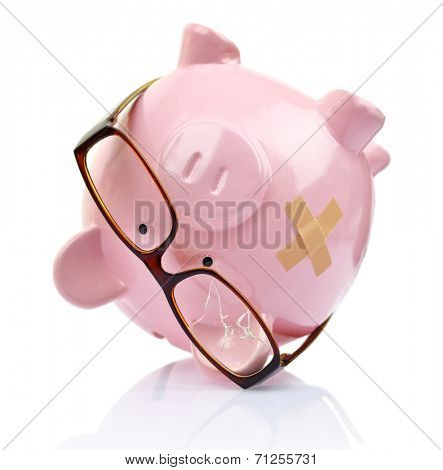 Piggy bank with broken eyeglasses and bandage upside down 