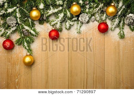 Christmas background with fresh firtree and  baubles on wood with bright snow 
