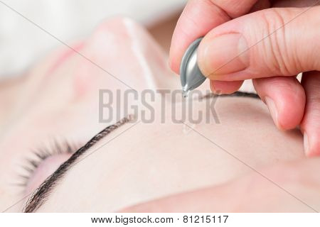 Serum capsule facial treatment of young woman in spa salon