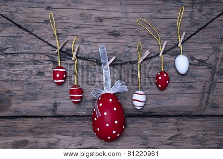 Many Red And White Easter Eggs And One Big Egg Hanging On Line