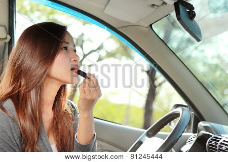 Young Woman Wearing Lipstick In The Car