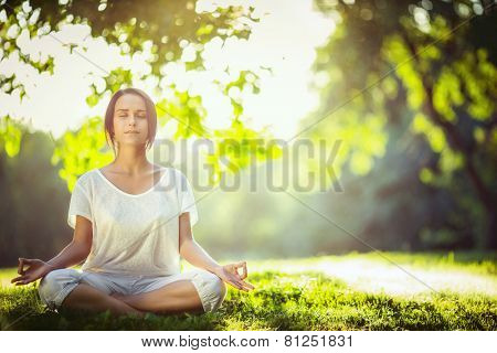 Young girl meditating in the park