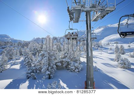 Back view of skiers in chairlift in snowy mountain